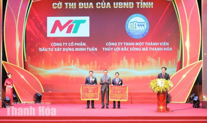 Chủ tịch UBND tỉnh Tô Anh Dũng trao Cờ thi đua của UBND tỉnh cho Tổng Công ty CP Đầu tư xây dựng Minh Tuấn và Công ty TNHH MTV Thủy lợi Bắc Sông Mã Thanh Hóa.