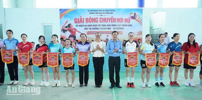 Ban tổ chức trao cờ lưu niệm cho các đội tham gia giải bóng chuyền hơi nữ tại lễ hội.
