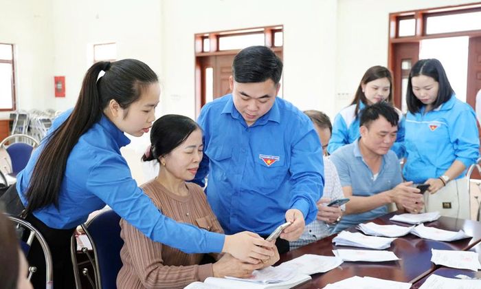  Chị Trần Kim Anh (ngoài cùng bên trái) cùng đoàn viên, thanh niên phường Tiền Phong hướng dẫn người dân cài đặt chữ ký số. 