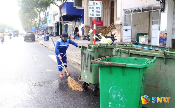 Công nhân quét dọn, thu gom rác đến vị trí tập kết sau khi đổ rác lên xe vận chuyển. Ảnh: HOÀNG HIỆP