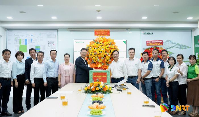 Đoàn công tác thành phố tặng hoa, quà chúc mừng Công ty TNHH Bia và Nước giải khát Heineken Việt Nam. Ảnh: T.CÔNG