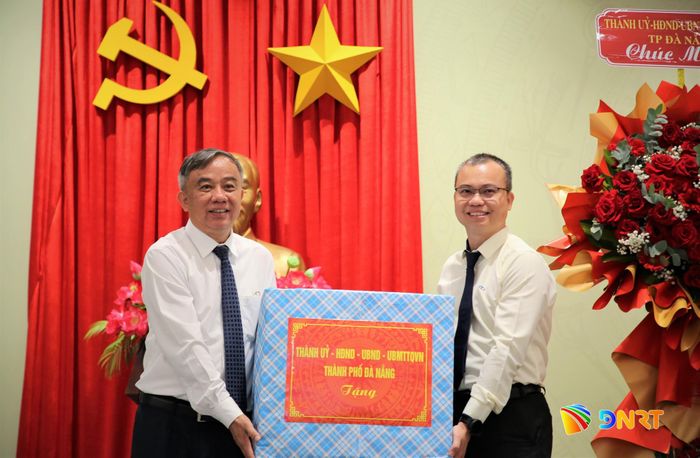 Phó Chủ tịch HĐND thành phố Trần Xuân Vinh (bên trái) tặng quà của lãnh đạo thành phố đến đại diện THACO. Ảnh: ALĂNG NGƯỚC