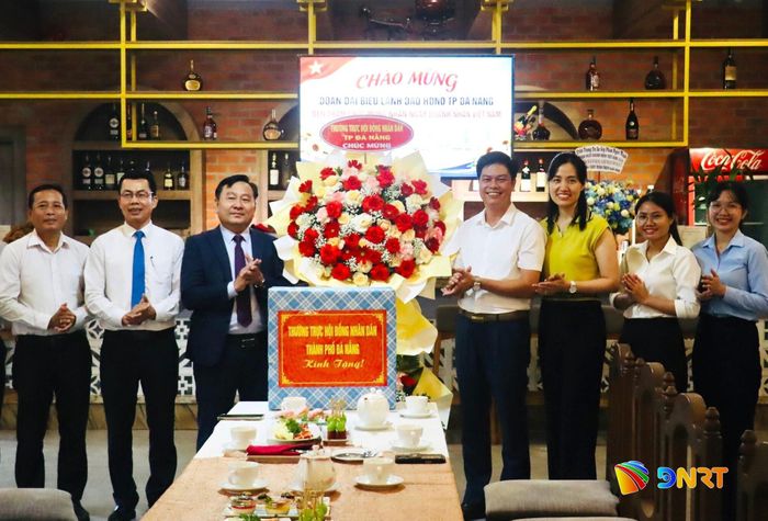 Phó Chủ tịch HĐND thành phố Nguyễn Công Thanh (thứ 3, từ trái sang) tặng hoa và quà cho đại diện Công ty TNHH Vật liệu xây dựng Phan Ngọc Anh. Ảnh: QUỐC TUẤN