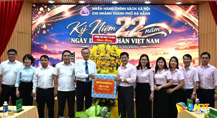 Phó Chủ tịch HĐND thành phố Đoàn Ngọc Hùng Anh (thứ 5, từ trái qua) tặng quà chúc mừng Chi nhánh Ngân hàng Chính sách xã hội thành phố Đà Nẵng. Ảnh: KHÁNH LINH