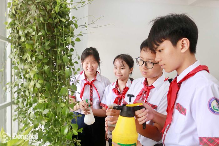 Huyền Trang và các bạn chăm sóc cây xanh trong lớp học. Ảnh: Minh Hạnh