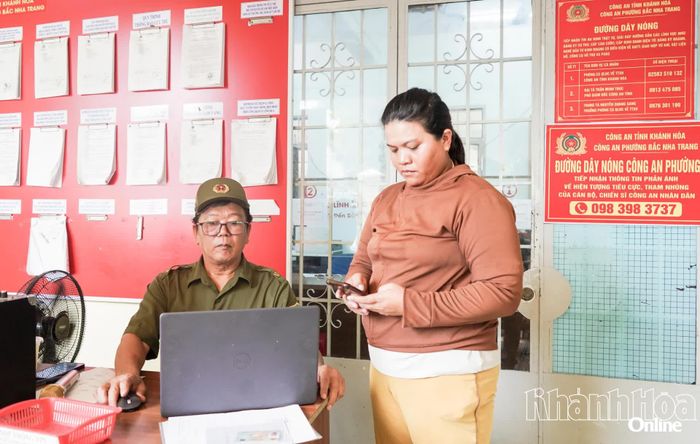 Ông Phạm Tiến Thọ - Tổ trưởng Tổ bảo vệ an ninh trật tự Tổ dân phố 2,  phường Bắc Nha Trang hỗ trợ người dân làm thủ tục hành chính tại trụ sở Công an phường.