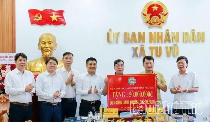 Đại diện Liên đoàn Doanh nghiệp tỉnh trao biểu trưng hỗ trợ kinh phí xóa nhà tạm cho hộ nghèo xã Tu Vũ.