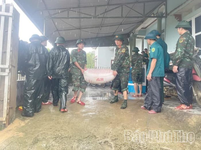 Lực lượng chức năng xã Dũng Tiến di dời người và tài sản đến nơi an toàn.