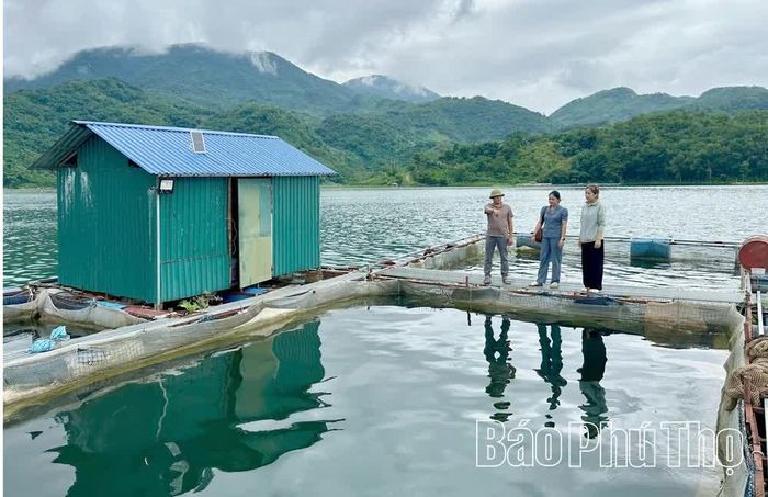 Người dân trao đổi về hoạt động nuôi cá lồng trên vùng lòng hồ sông Đà, một trong những hướng phát triển kinh tế thế mạnh của xã Tiền Phong.