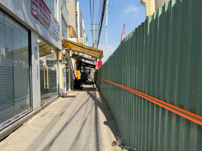 Để hạn chế ảnh hưởng đến việc đi lại, sinh hoạt và kinh doanh của người dân, phương án mở rộng lòng đường tạm, bố trí rào chắn được tính toán theo điều kiện thực tế từng khu vực. MAUR yêu cầu tổng thầu bố trí lực lượng điều tiết giao thông 24/7 tại các vị trí cần thiết, phối hợp với lực lượng chức năng và điều chỉnh phương án khi lưu lượng phương tiện thay đổi. Trong ảnh, khu vực rào chắn bố trí đường nhỏ cho nhà dân khu vực thi công có thể di chuyển.