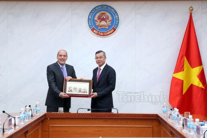 Bộ trưởng Ngô Văn Tuấn tặng quà lưu niệm cho Chủ tịch Fitch Ratings Ian Linnell. Ảnh: Đức Minh 