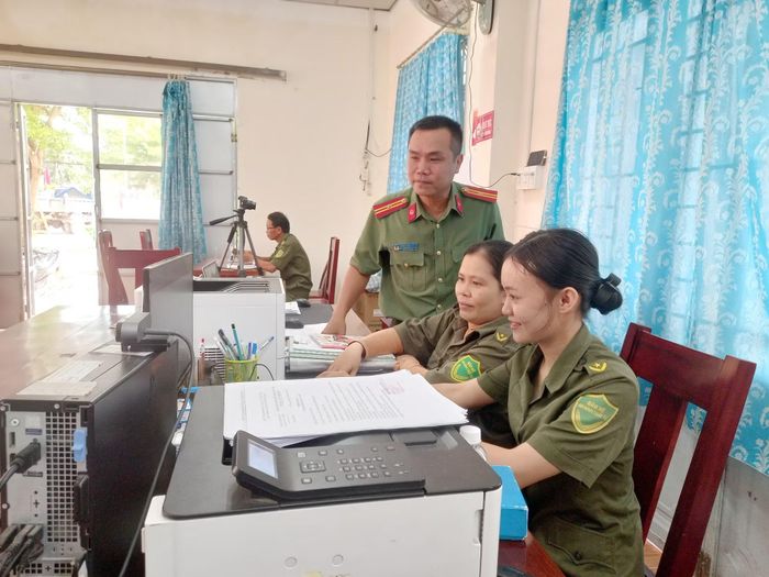 Công an xã Vạn Thắng hướng dẫn thành viên bảo vệ ANTT ở cơ sở thao tác kỹ thuật trên máy tính để hỗ trợ người dân đăng ký hồ sơ trực tuyến.
