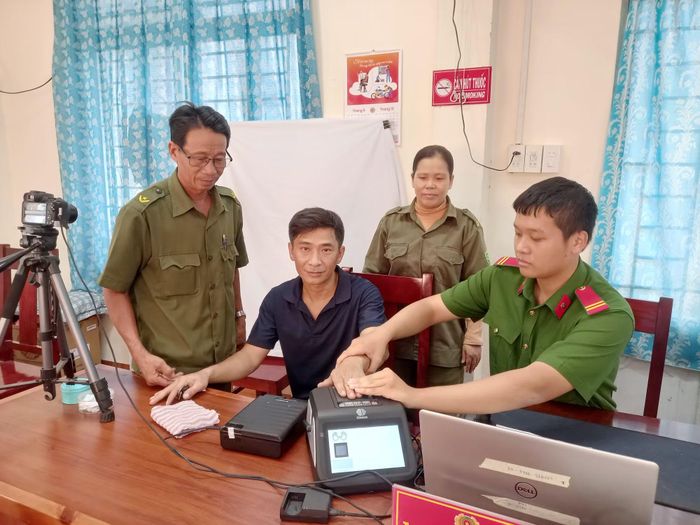 Công an xã Vạn Thắng thu nhận vân tay của người dân đăng ký làm căn cước. Ảnh: Hữu Toàn.