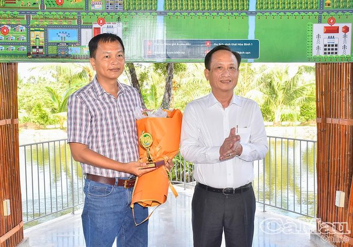 Chủ tịch HĐND tỉnh Phạm Văn Thiều, tặng hoa và quà chúc mừng ông Nguyễn Trung Kiên - đại diện Công ty TNHH Điện gió Hoà Bình 1.