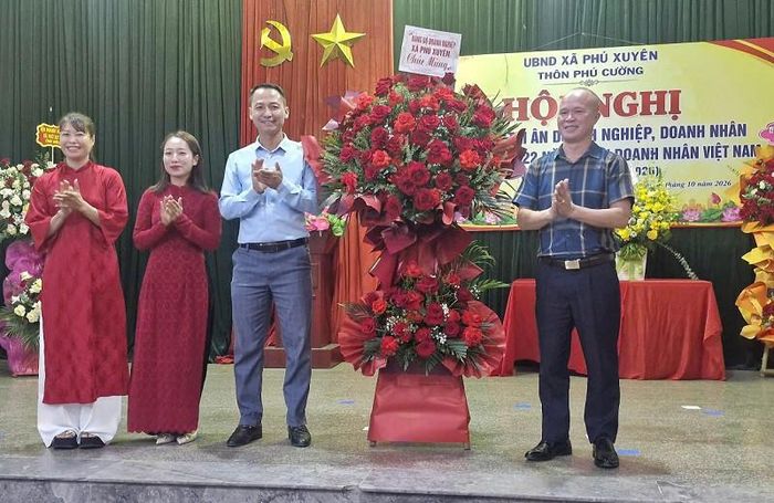 Lãnh đạo Đảng bộ Doanh nghiệp xã Phú Xuyên tặng hoa chúc mừng tại hội nghị gặp mặt, tôn vinh các doanh nghiệp, doanh nhân ở thôn Phú Cường. Ảnh: PV