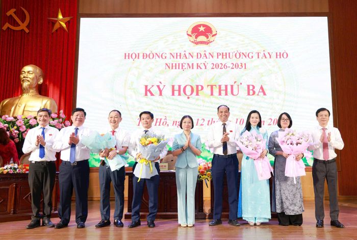 Phó Chủ tịch HĐND thành phố Hà Nội Phạm Thị Thanh Mai và Bí thư Đảng ủy, Chủ tịch HĐND phường Tây Hồ Nguyễn Đình Khuyến tặng hoa cho các cán bộ được bổ nhiệm tại các phòng, ban mới. Ảnh: Văn Tuyến