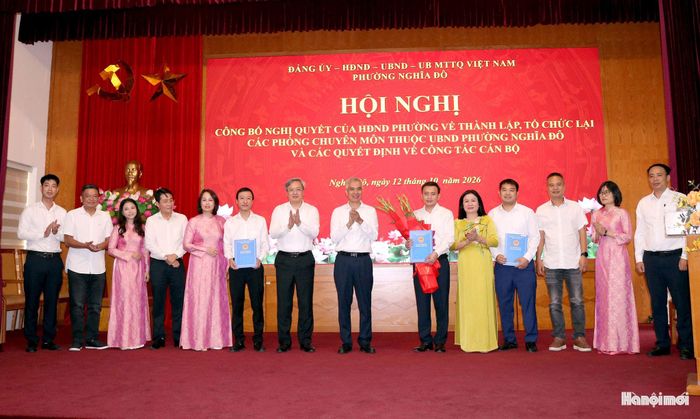 Lãnh đạo phường Nghĩa Đô trao quyết định thành lập Phòng Hạ tầng, Đô thị và Môi trường. Ảnh: MT