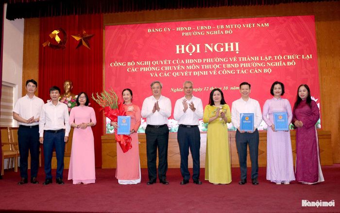 Lãnh đạo phường Nghĩa Đô trao quyết định thành lập Văn phòng HĐND-UBND phường. Ảnh: MT
