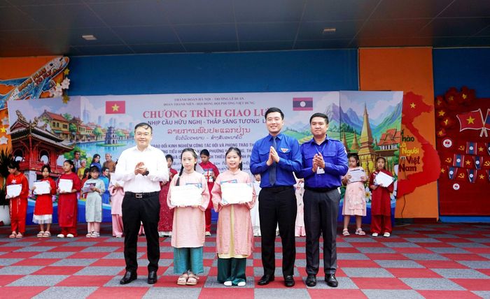 Lãnh đạo Thành đoàn Viêng Chăn, Thành đoàn Hà Nội và UBND phường Việt Hưng trao giải Nhất cuộc thi vẽ tranh “Sắc màu Hữu nghị Việt - Lào” tặng hai họa sĩ nhí. Ảnh: B.Duy