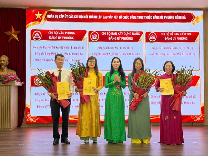 Phó Bí thư Thường trực Đảng uỷ phường Hồng Hà Phùng Mỹ Ngà trao quyết định, tặng hoa chúc mừng các đồng chí Bí thư Chi bộ. Ảnh: PV