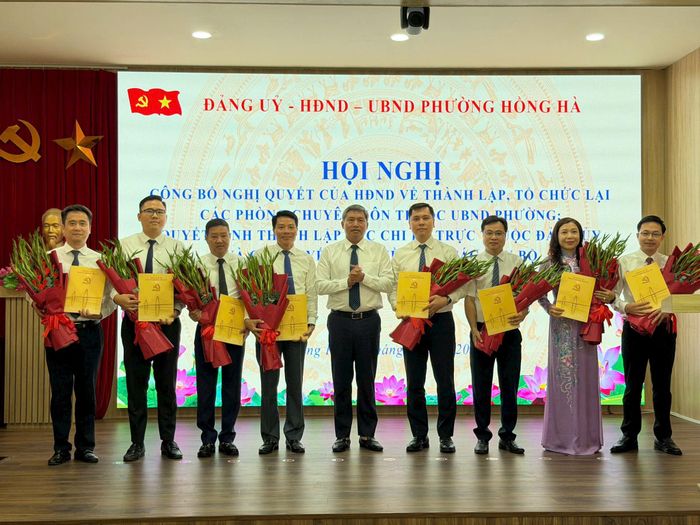 Chủ tịch UBND phường Hồng Hà Lê Hồng Thắng trao quyết định, tặng hoa chúc mừng lãnh đạo các phòng chuyên môn thuộc UBND phường. Ảnh: PV