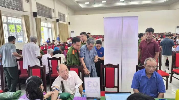 Thiếu tá Chu Quang Anh hỗ trợ người dân khó khăn trong đi lại tại điểm thu nhận ADN thân nhân liệt sỹ xã Đoài Phương