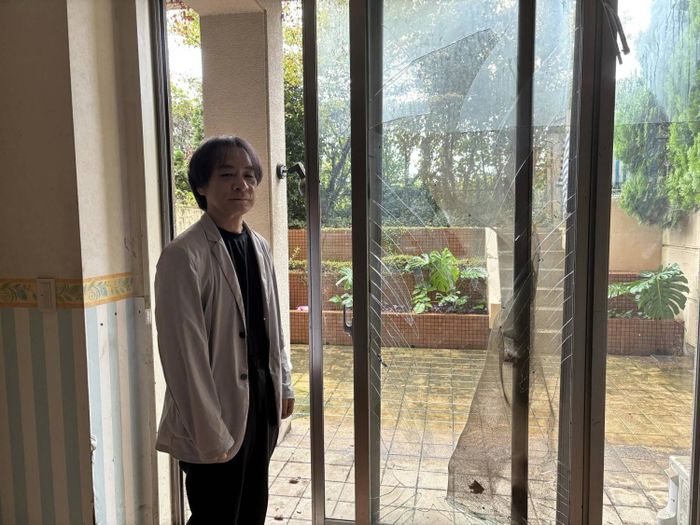  Ông Nishizawa đứng cạnh cánh cửa hiên bị mưa lớn phá hủy. Ảnh: Japan Times. 