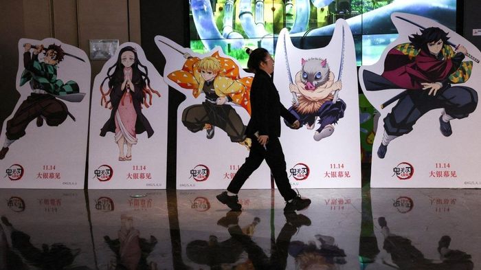  Một người phụ nữ đi ngang qua mô hình quảng bá cho bộ phim Demon Slayer bên ngoài rạp chiếu phim ở Bắc Kinh, Trung Quốc. Ảnh: Reuters. 