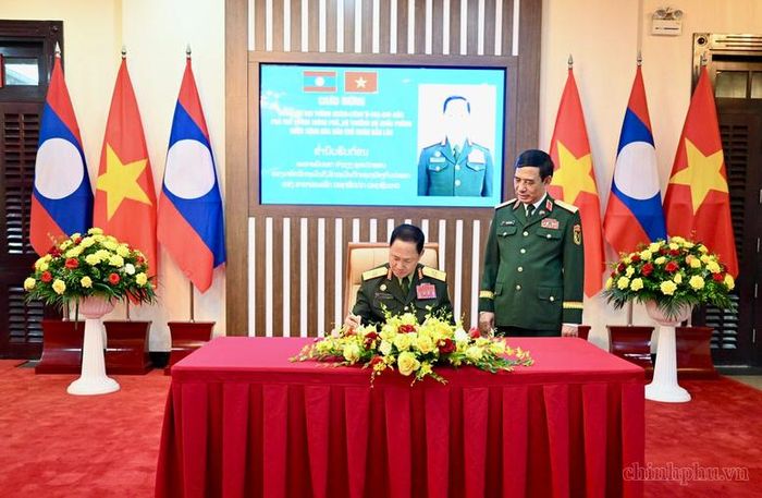 Phó Thủ tướng Chính phủ, Bộ trưởng Bộ Quốc phòng Lào Khamliang Outhakaysone ghi sổ lưu niệm - Ảnh: chinhphu.vn/Diệu Anh