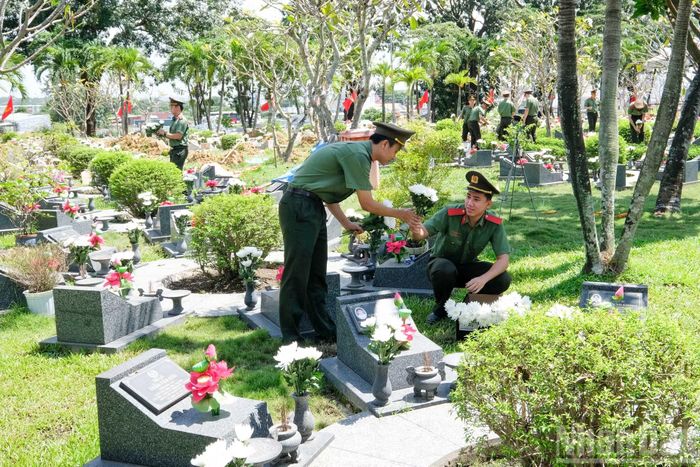 Lực lượng an ninh và cán bộ quản trang khẩn trương thực hiện công tác cắm hoa, chỉnh trang khu vực an táng tại Nghĩa trang Liệt sĩ Thành phố Hồ Chí Minh.