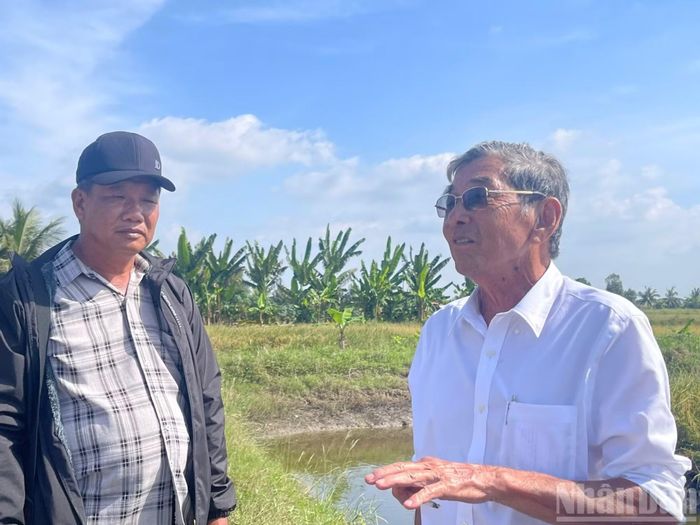 Kỹ sư Hồ Quang Cua trao đổi với người dân về kỹ thuật canh tác. (Ảnh: THIÊN LAM)