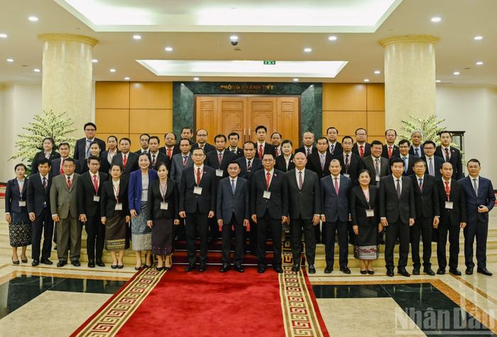 Thường trực Ban Bí thư Trần Cẩm Tú cùng các đại biểu với đoàn cán bộ cấp cao Đảng Nhân dân Cách mạng Lào. (Ảnh: DUY LINH)