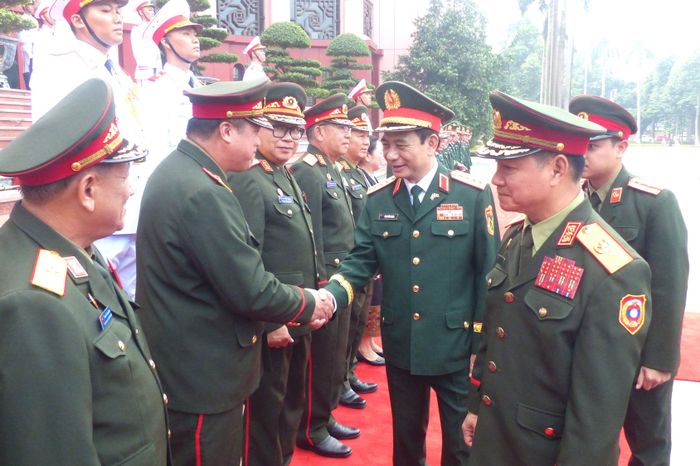  Đại tướng Phan Văn Giang chào các đại biểu đoàn Bộ Quốc phòng Lào tại lễ đón. Ảnh: TRẦN BÌNH 