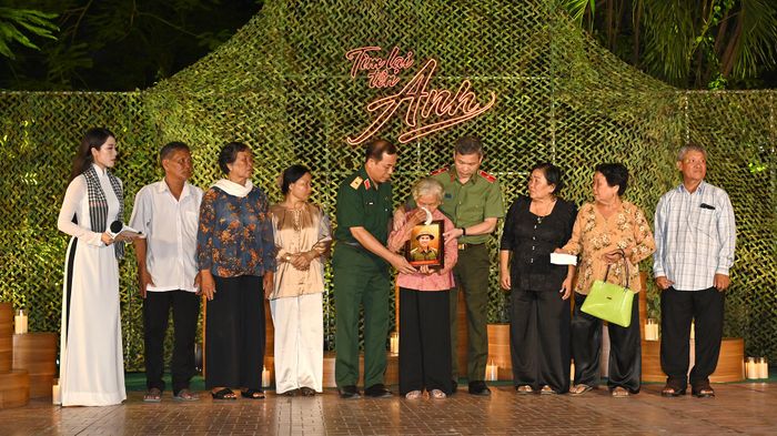Thiếu tướng Vũ Văn Điền, Tư lệnh Bộ Tư lệnh TPHCM và Thiếu tướng Tạ Văn Đẹp, Phó Giám đốc Công an TPHCM trao tặng bà Nguyễn Thị Lệ cùng gia đình bức chân dung liệt sĩ Huỳnh Văn Quên. Ảnh: MẠNH THẮNG