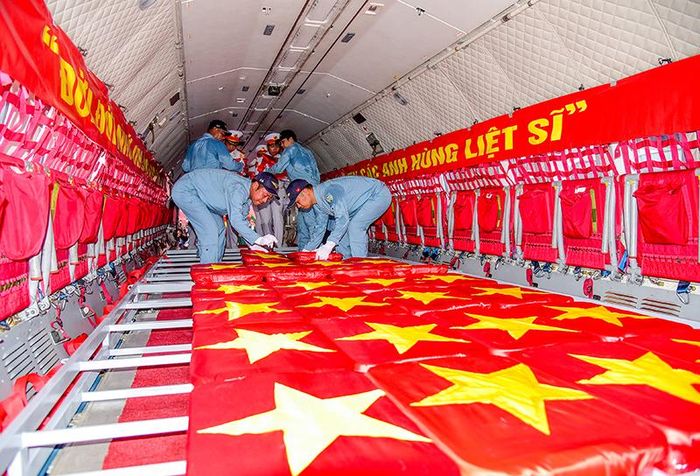  Cán bộ, chiến sĩ trang trọng đặt các mẫu hài cốt liệt sĩ lên máy bay. Ảnh: MẠNH THẮNG 