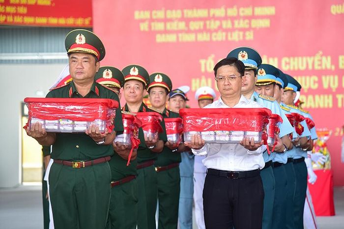  Trung tướng Lê Xuân Thế, Tư lệnh Quân khu 7 và Phó Chủ tịch UBND TPHCM Nguyễn Mạnh Cường cùng các đại biểu thực hiện nghi thức đưa mẫu hài cốt liệt sĩ lên máy bay. Ảnh: MẠNH THẮNG 