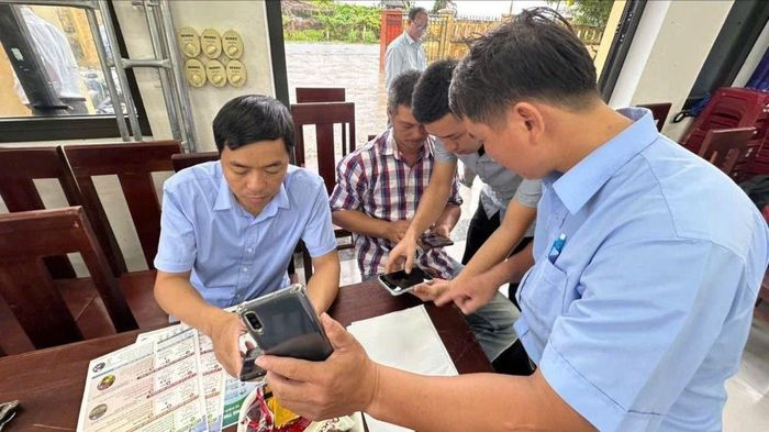 Chi cục Thủy lợi và biến đổi khí hậu TP Huế hướng dẫn người dân sử dụng thông tin cảnh báo thiên tai qua điện thoại thông minh và tờ rơi. Ảnh minh hoạ: VĂN THẮNG