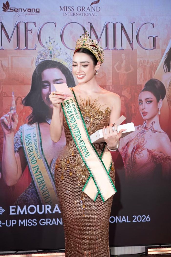 Tại buổi homecoming, Emoura Phạm chăm chú đọc thiệp và đón nhận những món quà từ khán giả. Người đẹp bày tỏ sự biết ơn trước tình cảm mà mọi người dành cho cô sau hành trình thi quốc tế.