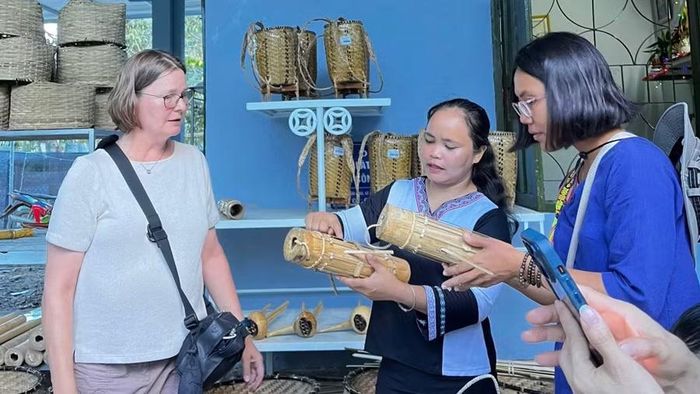 Du khách tìm hiểu về đàn Cha pi tại Làng du lịch cộng đồng Hòn Dung.