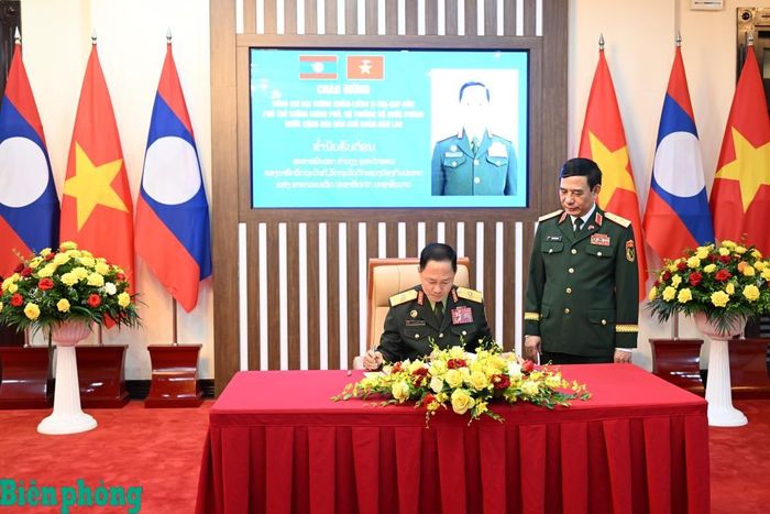 Đại tướng Khamliang Outhakaysone ghi sổ lưu niệm tại trụ sở Bộ Quốc phòng Việt Nam. Ảnh: Trọng Hải