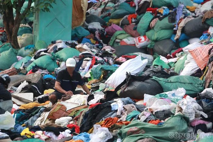 Ghi nhận tại hiện trường, bên cạnh hoạt động thu gom bằng máy móc, một số người dân cũng đến lựa chọn quần áo cũ và mang đi bằng bao tải.