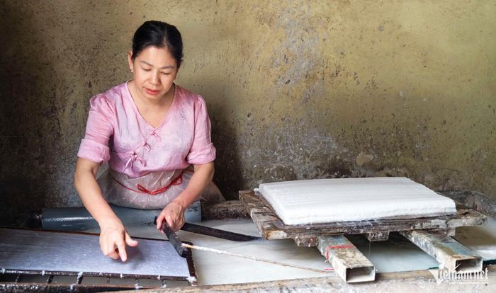 Người thợ làng Đống Cao tỉ mỉ thực hiện công đoạn xeo giấy dó bằng phương pháp thủ công