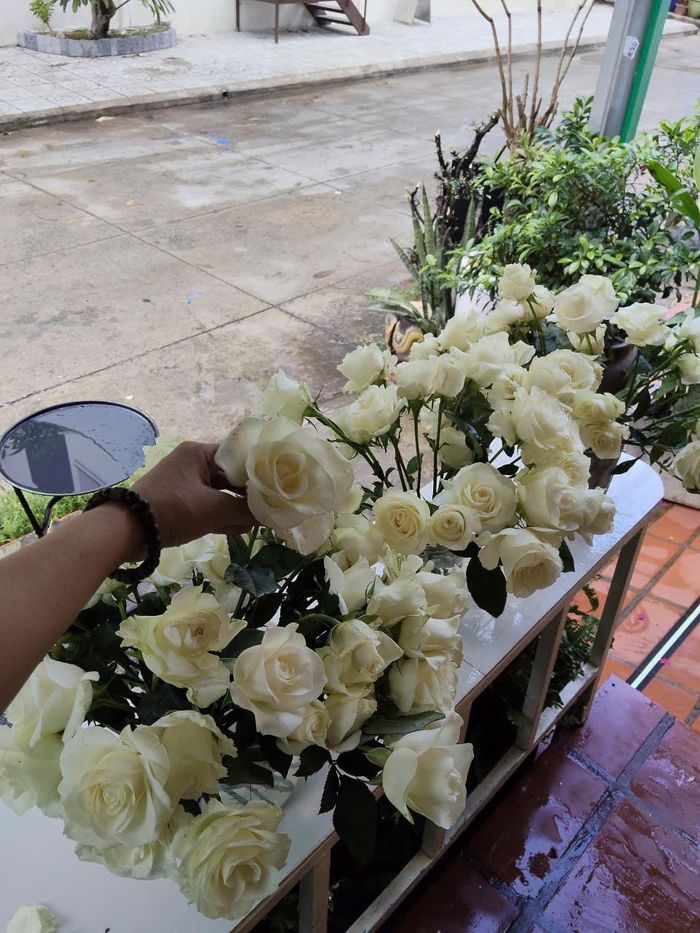 Chị Nghĩa cùng mọi người hoàn tất việc chuẩn bị hoa hồng để tặng người dân đến tiễn đưa các liệt sĩ. Ảnh: Nhân vật cung cấp