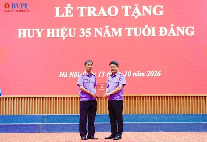  Đồng chí Nguyễn Huy Tiến, Bí thư Đảng ủy, Viện trưởng VKSND tối cao trao Quyết định về việc tặng Huy hiệu 35 năm tuổi Đảng cho đồng chí Nguyễn Duy Giảng.