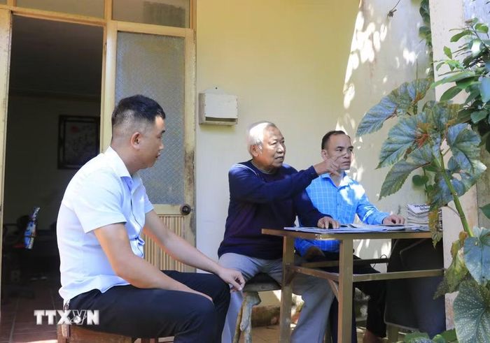 Cán bộ xã Hưng Khánh (Lào Cai) tuyên truyền, vận động nhân dân góp công, góp sức mở rộng đường giao thông. (Ảnh: Đinh Thùy/TTXVN)