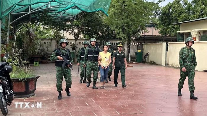 Bộ đội Biên phòng áp giải 2 đối tượng Hạng Seo Dũng và Hạng Thị Mua. (Ảnh: TTXVN phát)