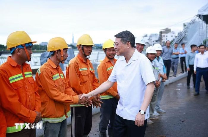 Thủ tướng Lê Minh Hưng với công nhân, kỹ sư thi công Dự án xây dựng hạ tầng và cải tạo môi trường kênh Tham Lương-Bến Cát-Rạch Nước Lên, tại phường An Nhơn. (Ảnh: Dương Giang/TTXVN)