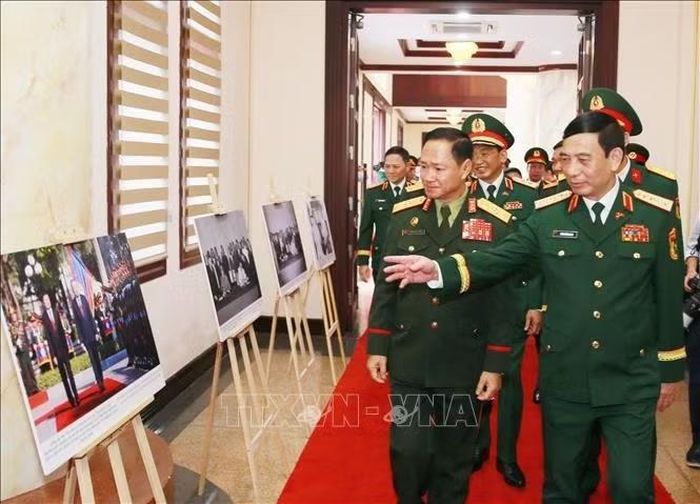 Đại tướng Khamliang Outhakaysone, Ủy viên Bộ Chính trị, Phó Thủ tướng, Bộ trưởng Bộ Quốc phòng Lào tham quan triển lãm ảnh trước hội đàm. Ảnh: Trọng Đức/TTXVN