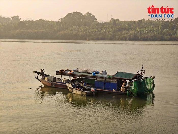 Thuyền cá thô sơ sử dụng kích điện để khai thác thủy sản trên sông Hồng.