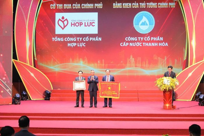 Thừa ủy quyền Thủ tướng Chính phủ, Bí thư Tỉnh ủy Thanh Hóa Lê Đức Thái trao Cờ thi đua của Chính phủ cho Tổng Công ty CP Hợp Lực được và Bằng khen của Thủ tướng Chính phủ cho Công ty CP Cấp nước Thanh Hóa. Ảnh: Xuân Nghĩa